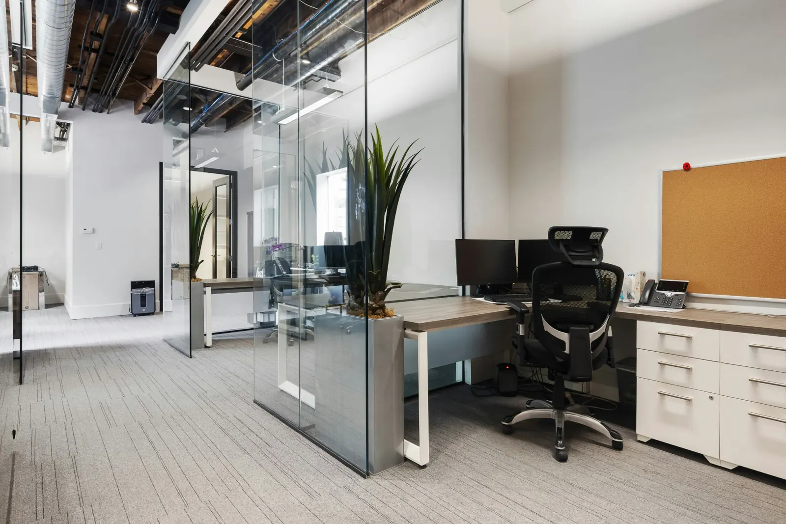 Modern office workspace with glass walls and desks